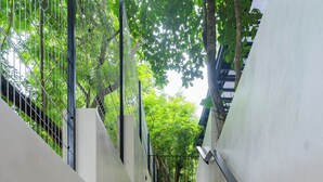 A concrete staircase with metal railings and a white wall on one side. - Casita Backdoor: Jungle Retreat, Sleeps 4-6 (Nosara)