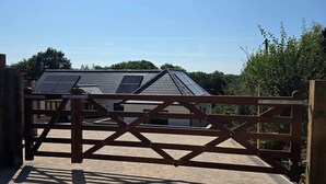 A gated entrance to a building with a sloped roof and solar panels.
