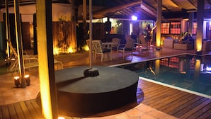 An outdoor pool area with a circular seating area, wooden deck, and lounge chairs. - Pousada Liberte-se in Búzios  (Buzios)