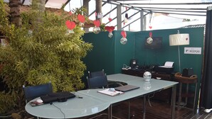 A conference room with a glass table, two chairs, a laptop, and a whiteboard. - Pousada Liberte-se in Búzios  (Buzios)