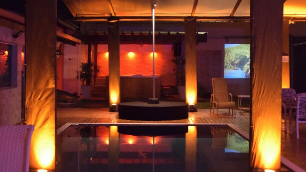 A modern indoor pool area with a glass enclosure, wooden flooring, and ambient lighting. - Pousada Liberte-se in Búzios  (Buzios)