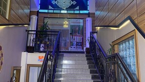 A grand staircase with ornate railings, leading to a lobby area with a decorative ceiling and a sign for 'AFCON TURKISH TECHNOLOGIES'. - Marrisson residence (Abuja)