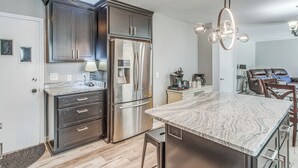 A modern kitchen with dark cabinetry, stainless steel appliances, and a marble countertop. - 4 Mi to Loris Nature Park: Family Home w/ Yard (Loris)