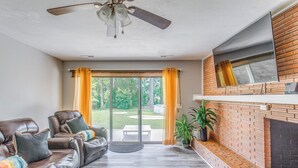 A living room with a fireplace, leather sofas, and a sliding glass door leading to a patio. - 4 Mi to Loris Nature Park: Family Home w/ Yard (Loris)