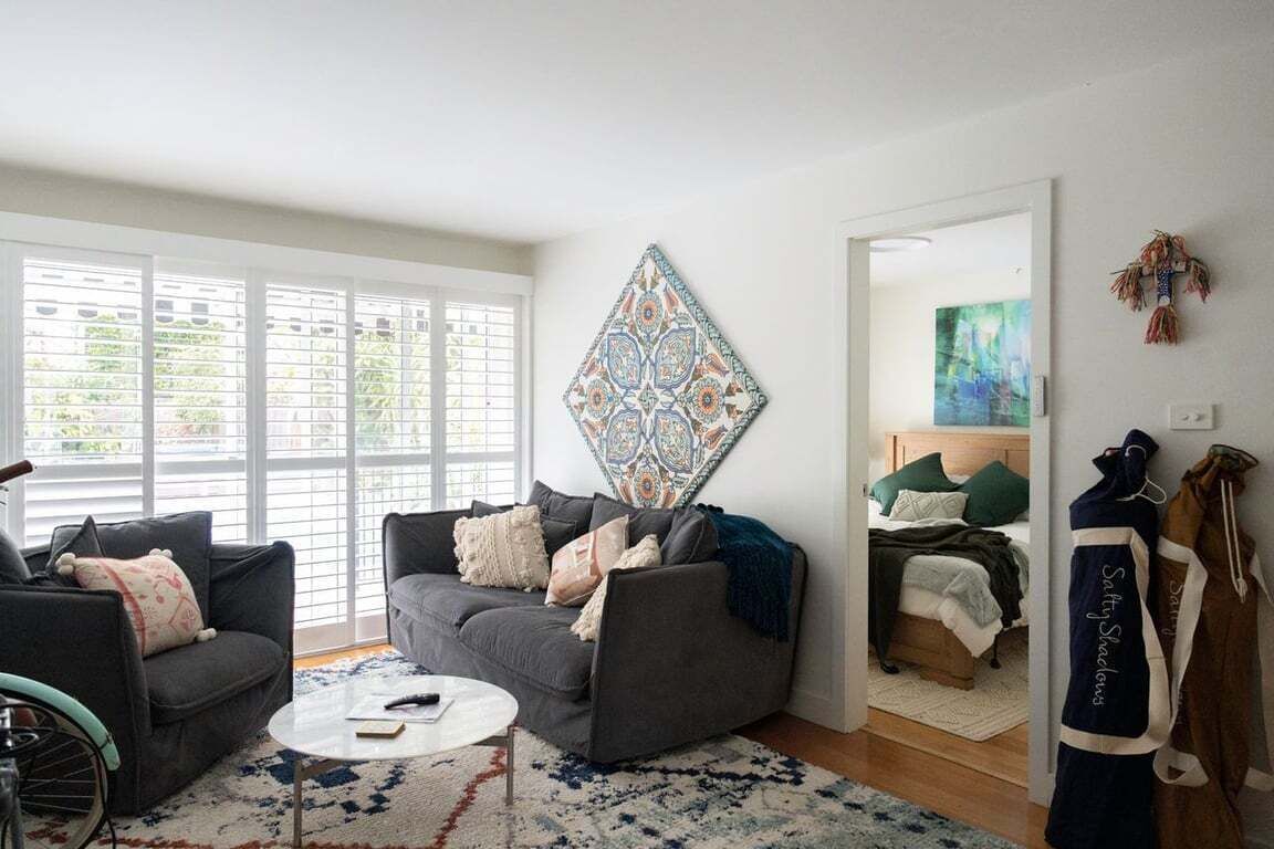 A living room with a sofa, armchair, coffee table, and a bicycle.