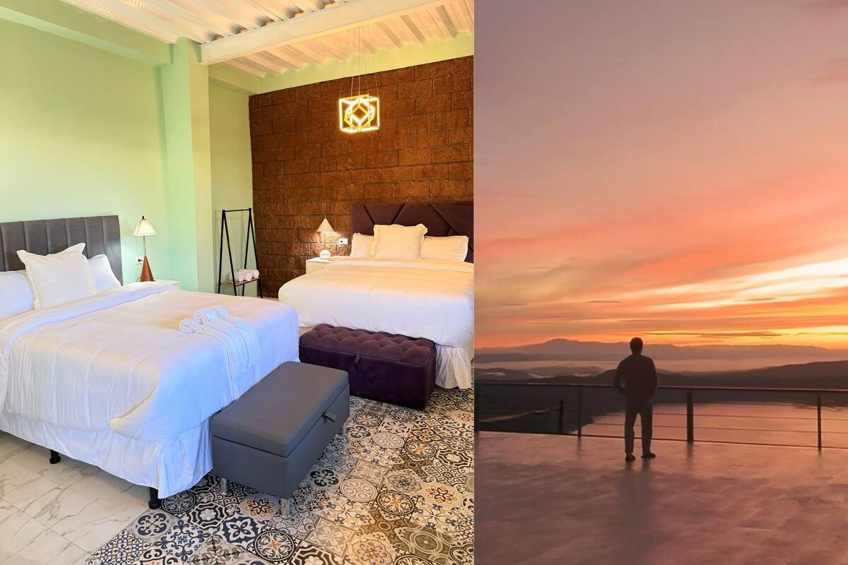 A hotel room with a large bed, a smaller bed, a nightstand, a lamp, a wall-mounted light, and a patterned floor.