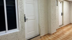 A hallway with doors numbered 125 and 124, wooden flooring, and textured walls.