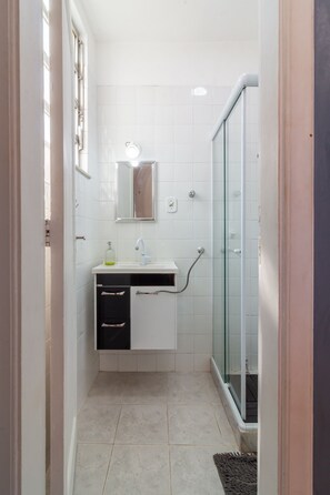 Chuveiro, secador de cabelo, toalhas de banho, shampoo