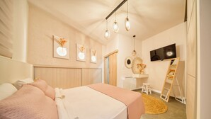 Een moderne slaapkamer met een bed, nachtkastjes, een televisie en kunstwerken aan de muren.