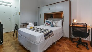 Une chambre à coucher avec un lit, un bureau, une chaise et une armoire.