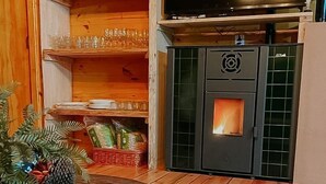 A cozy room with a fireplace, wooden shelves, and a television.