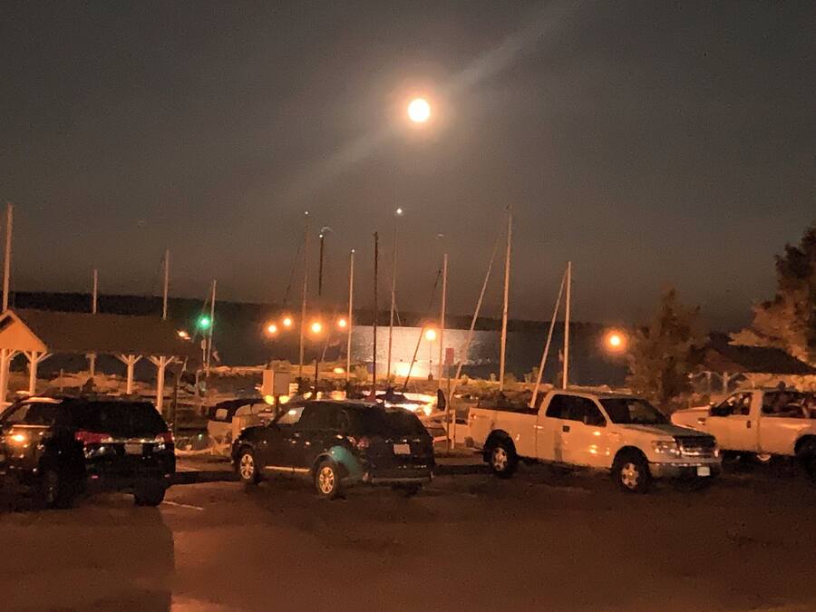 A parking lot with several cars and a building in the background.