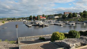 A marina with boats docked, a river, and buildings in the background. - LEISURE INN (Temiskaming Shores)