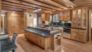 Una cocina amplia con armarios de madera, encimeras de granito y una isla central.