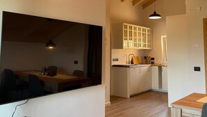 Een moderne keuken met witte kastjes en een houten plafond.