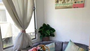 A cozy seating area with a wooden table, a wicker basket with items, and a green leaf-shaped plate. - Popular resort- with indoor and outdoor pool (Newquay)