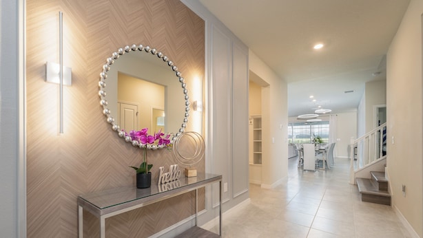 A modern hallway with a glass console table, a decorative mirror, and a "hello" sign. - New Jungle Adventure 9BR Villa by Disney (Davenport)