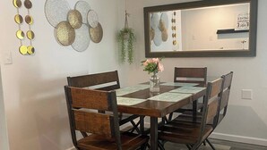 A dining area with a rectangular table, six chairs, and a hanging plant. - Casa Patron/Quaint home near lake (Livingston)