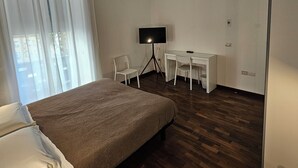 A bedroom with a bed, a desk, a chair, a TV, and a window with curtains. - Double or Twin - Private Outdoor Bathroom and Private Parking in Loco (Potenza)