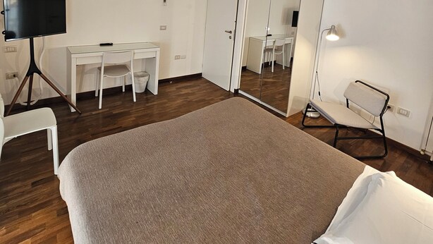 A bedroom with a bed, a desk, a chair, a wardrobe, and a mirror. - Double or Twin - Private Outdoor Bathroom and Private Parking in Loco (Potenza)