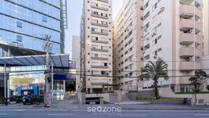 A modern building with a glass facade, a parking area, and a sign for 'CAIXA'. - Apto Central a 600m da Beira-Mar Norte SGS0106 (Florianópolis)