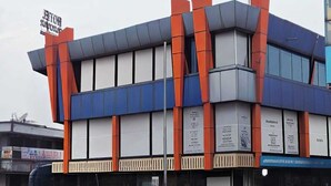 A hotel with a modern facade, featuring a prominent sign for the Hotel Sarovar Grand. - HOTEL SAROVAR GRAND  (Ahmedabad)