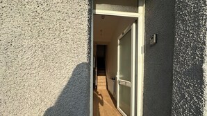A narrow entrance with a sliding glass door leading to a hallway.