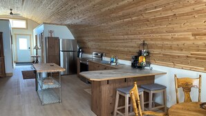 Una cocina moderna con paneles de madera, electrodomésticos de acero inoxidable y una isla central con taburetes de bar.