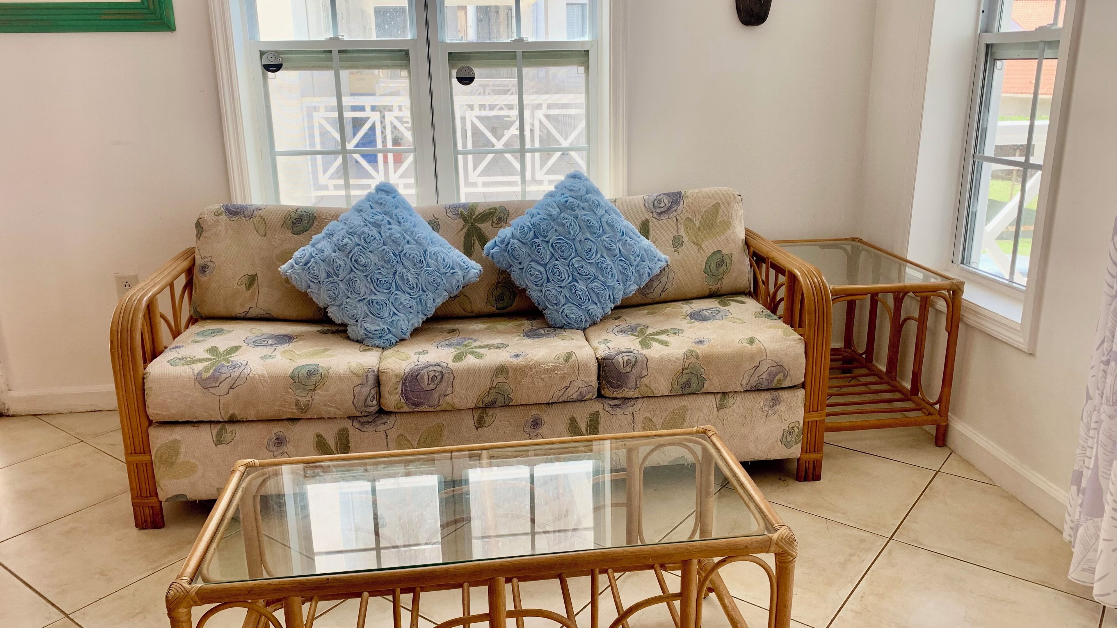 A room with a sofa and a glass-top table.