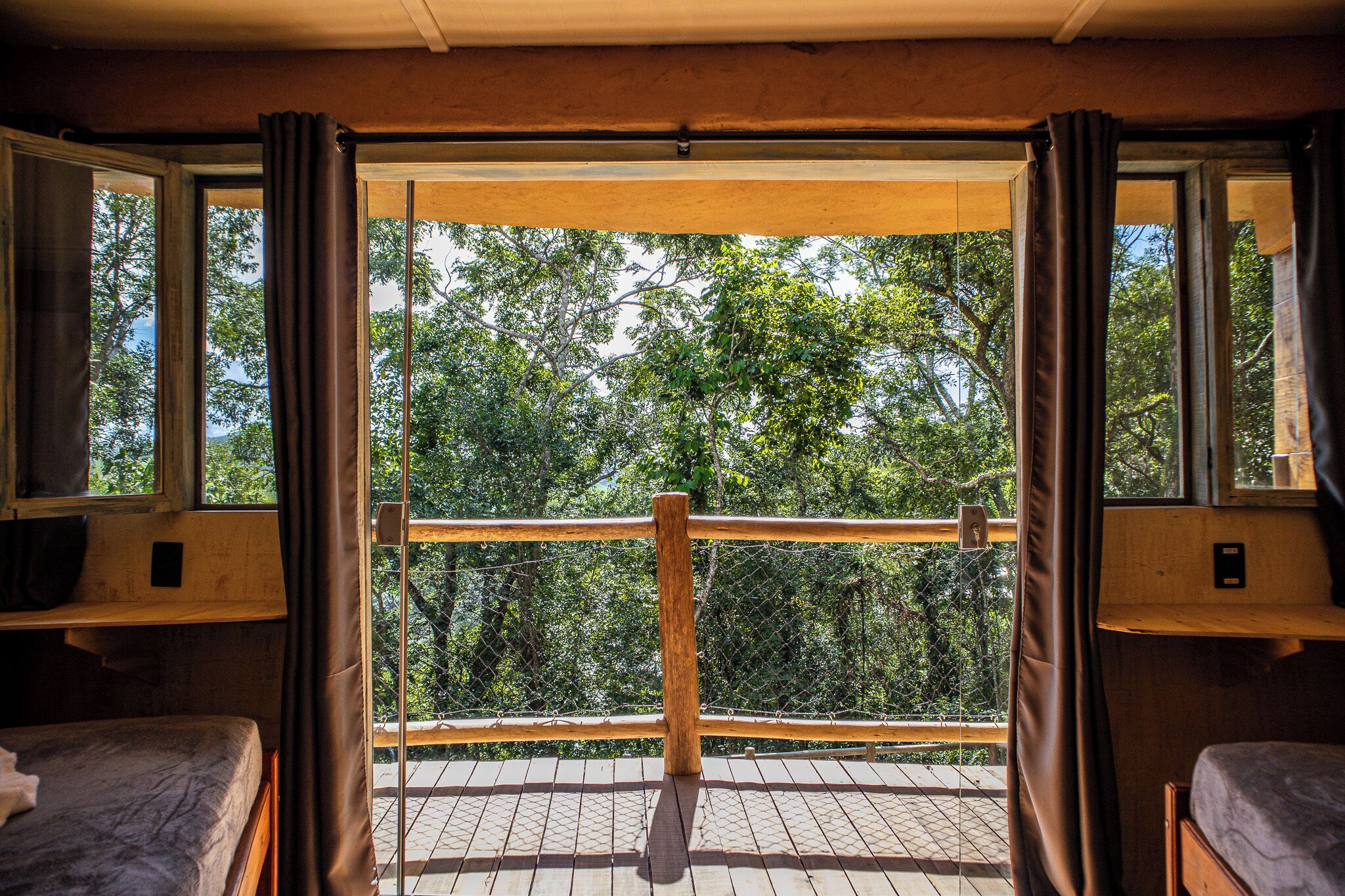 A room with a bed, a window, and a view of trees.