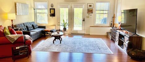 Una sala de estar con sofá, mesa de centro y televisión.