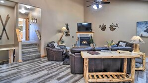 A modern living room with a fireplace, leather sofas, and a television. - Family-Friendly Home w/ Hot Tub: 1 Mile to Downtown (Estes Park)