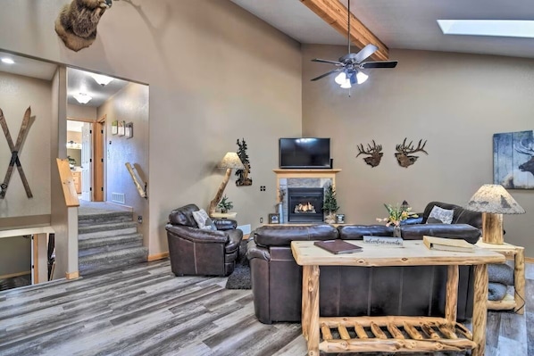 A modern living room with a fireplace, leather sofas, and a television. - Family-Friendly Home w/ Hot Tub: 1 Mile to Downtown (Estes Park)