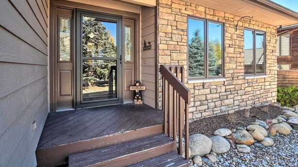 A house with a stone exterior, a wooden deck, and a 'Welcome' sign. - Family-Friendly Home w/ Hot Tub: 1 Mile to Downtown (Estes Park)