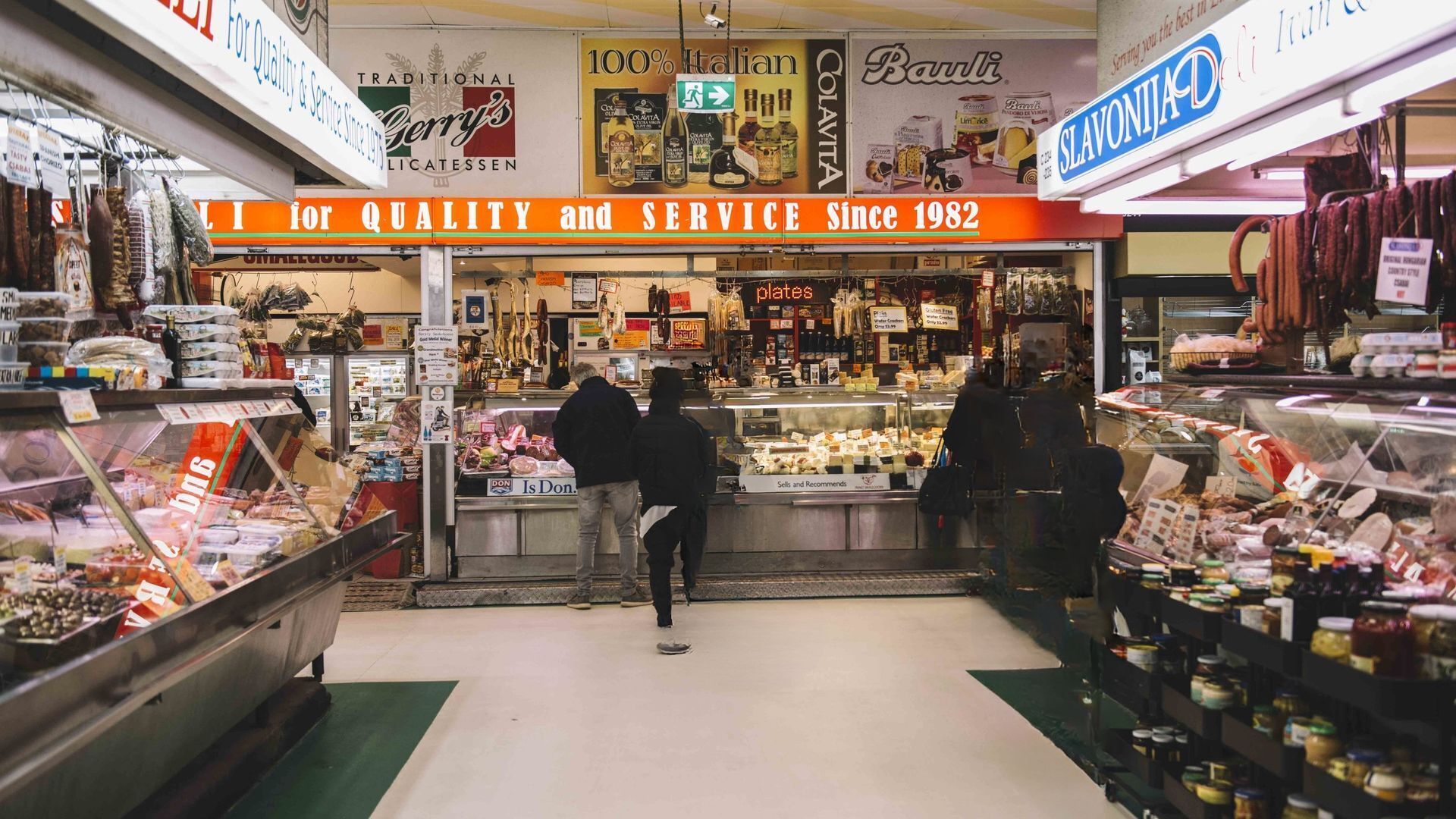 A deli with a sign stating 'For Quality and Service Since 1982' and various deli products on display.
