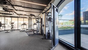 Un gimnasio con cintas de correr, elípticas y equipo de levantamiento de pesas.
