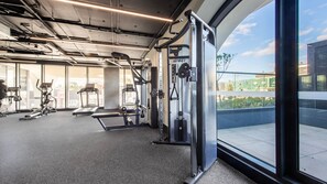 Uma academia com esteiras, elípticos e equipamentos de musculação.