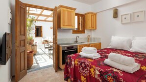 A compact hotel room with a bed, a small kitchenette, and a bathroom. - Villa Vasoula Lindos  (Lindos)