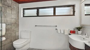 A bathroom with a toilet, sink, and window. - Beachfront 7 Penthouse (Sawtell)