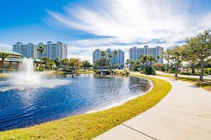 A park with a fountain, a pond, and a walking path.