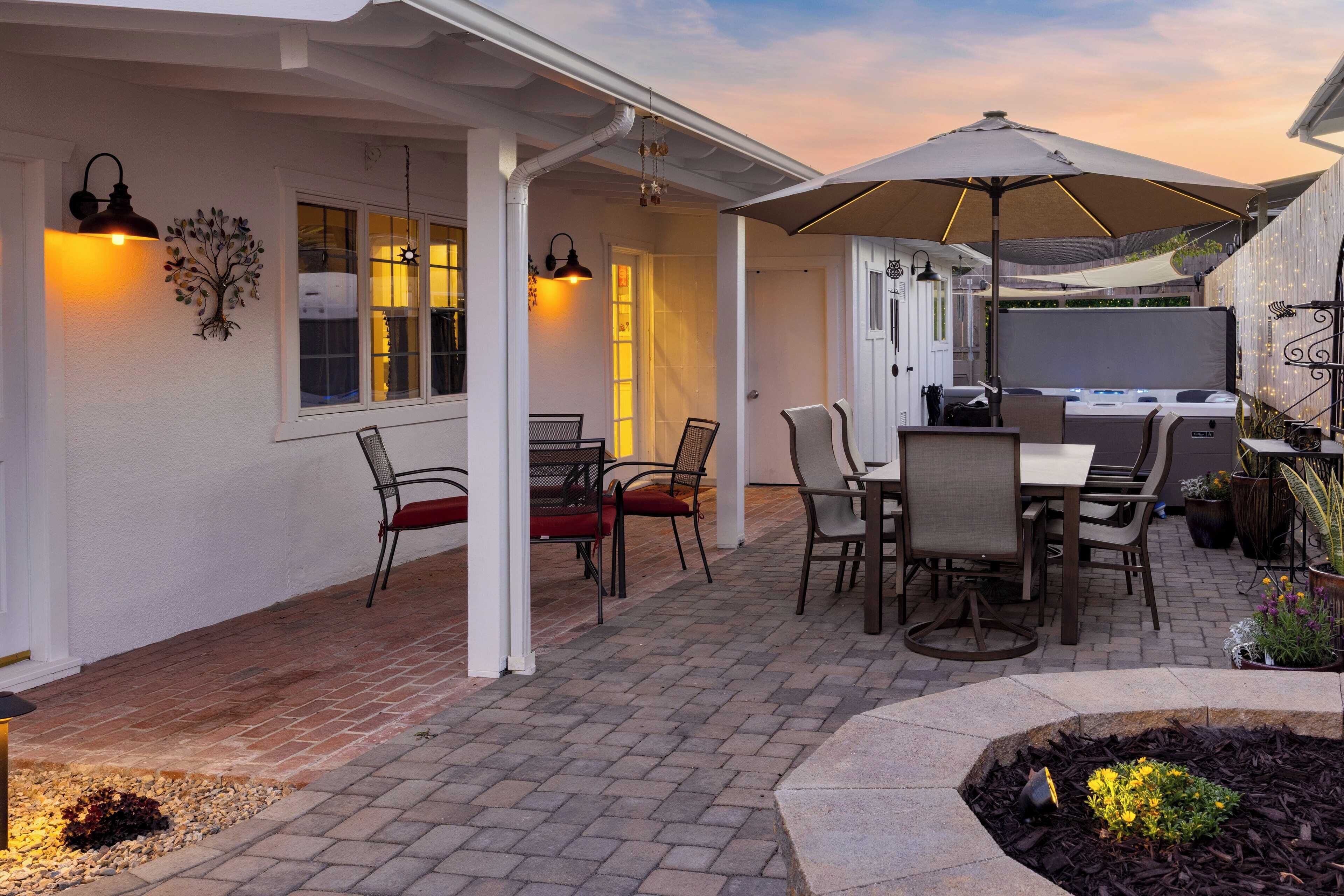 A patio with outdoor seating, a grill, and decorative lighting.