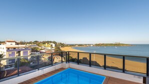 Una piscina con vista sulla spiaggia e sull'oceano.