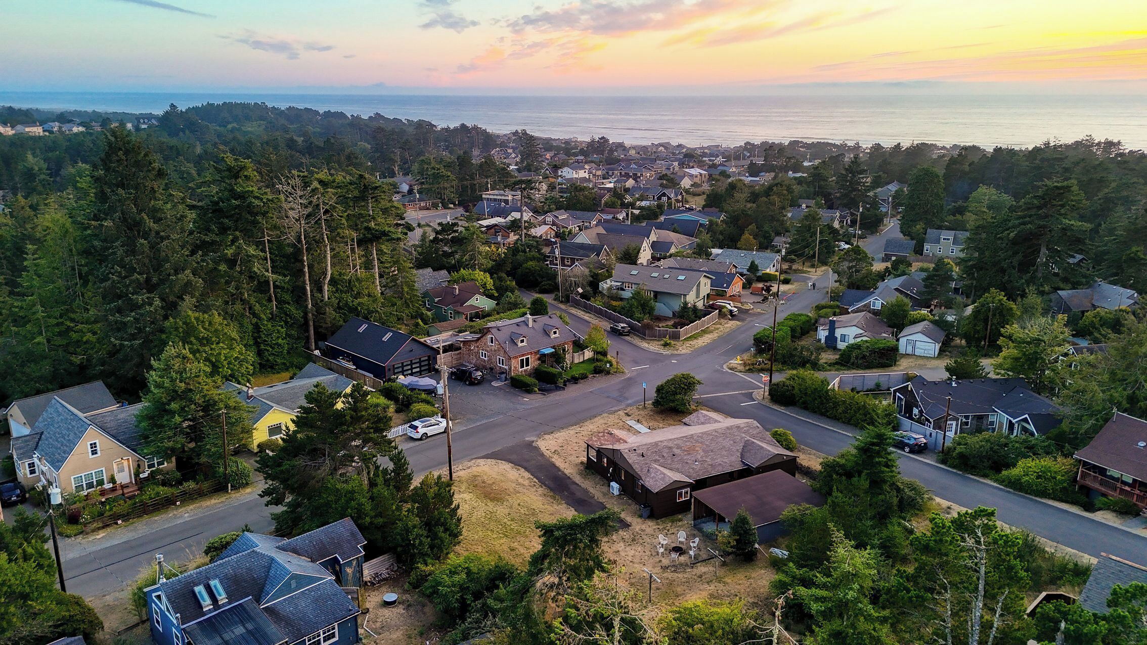 A residential area with houses, roads, and a view of the sea.