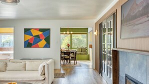 Ein modernes Interieur mit Essbereich, einer Couch und einem großen abstrakten Gemälde.