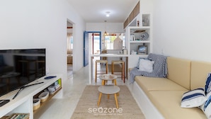 A modern living room with a TV, sofa, and dining area. - Piece of Greece on the Santa Catarina Coast Umc002 (Barra Velha)