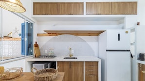 A kitchen with wooden cabinets, a white countertop, a gas stove, a sink, and a white refrigerator. - Piece of Greece on the Santa Catarina Coast Umc002 (Barra Velha)