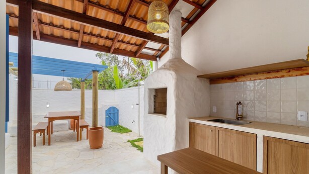 A compact kitchen with a built-in oven, wooden cabinets, and a blue door. - Piece of Greece on the Santa Catarina Coast Umc002 (Barra Velha)