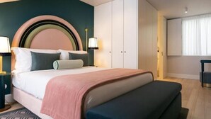 Une chambre à coucher moderne avec un lit, des tables de chevet, une armoire et une fenêtre.