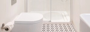 Une salle de bain comprenant des toilettes, une douche et une baignoire.