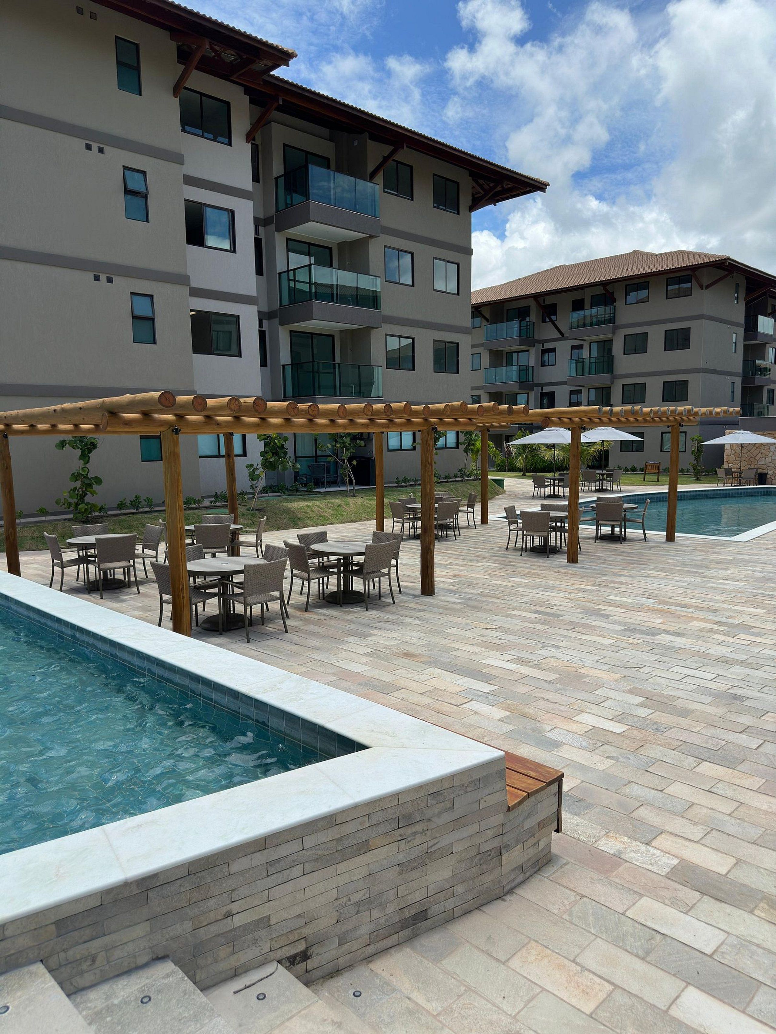 Zona de piscina con mobiliario exterior y una estructura de pérgola.